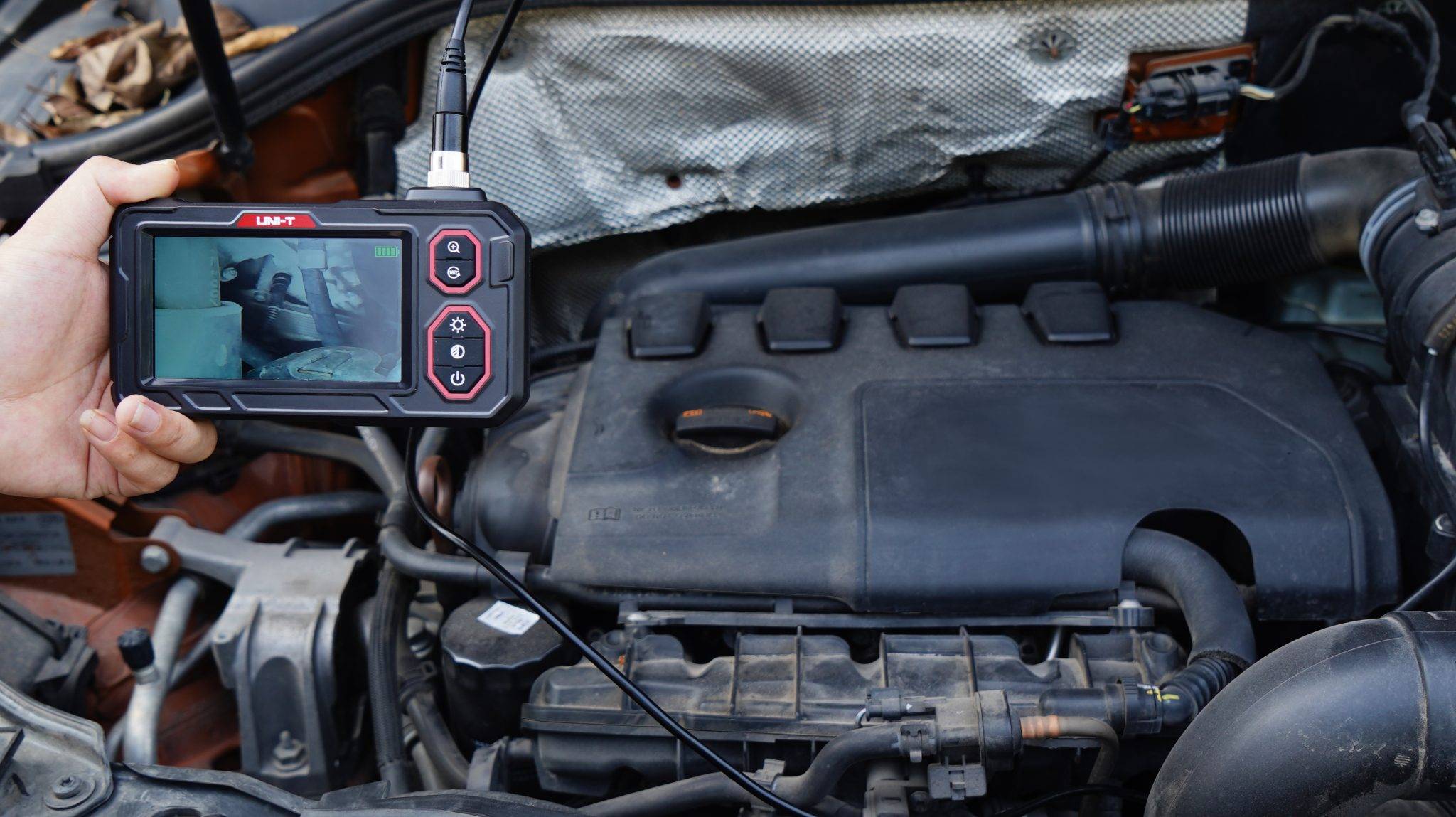 Das UNI-T UT667 Endoskop wird zur Inspektion eines schwer zugänglichen Bereichs in einem Automotor verwendet.