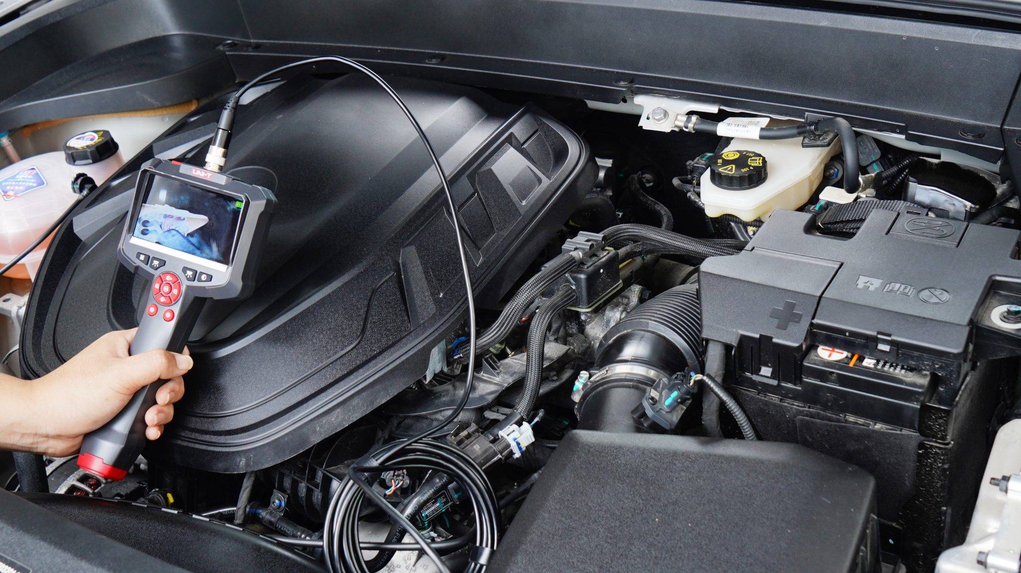 Einsatz des UNI-T UT665P Endoskops zur Fehlersuche im Motorraum eines Autos.