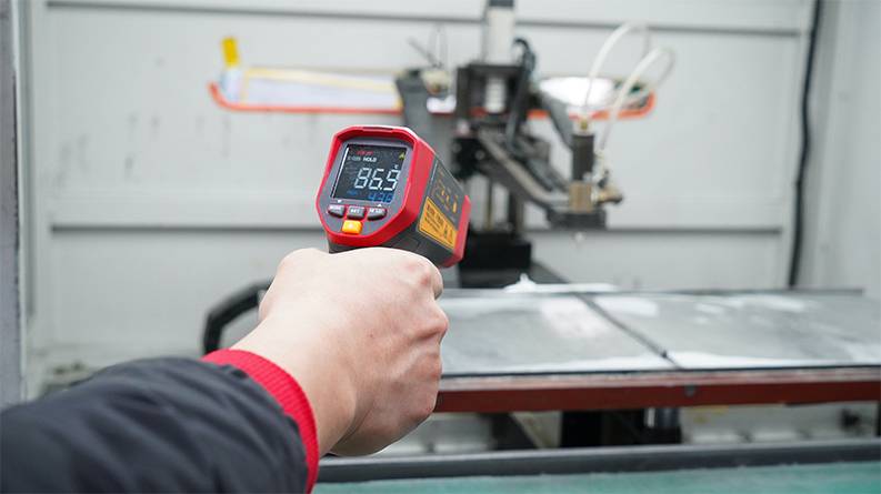 Das UNI-T UT305S Infrarot-Thermometer wird zur Temperaturüberwachung an einer Maschine in einer Werkstatt verwendet.