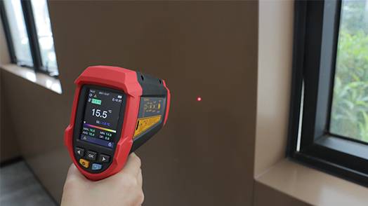 Einsatz des UT305C+ Infrarot-Thermometers zur präzisen Messung der Oberflächentemperatur einer Wand, ideal für Taupunkt-Detektion und Erkennung von Wärmebrücken.