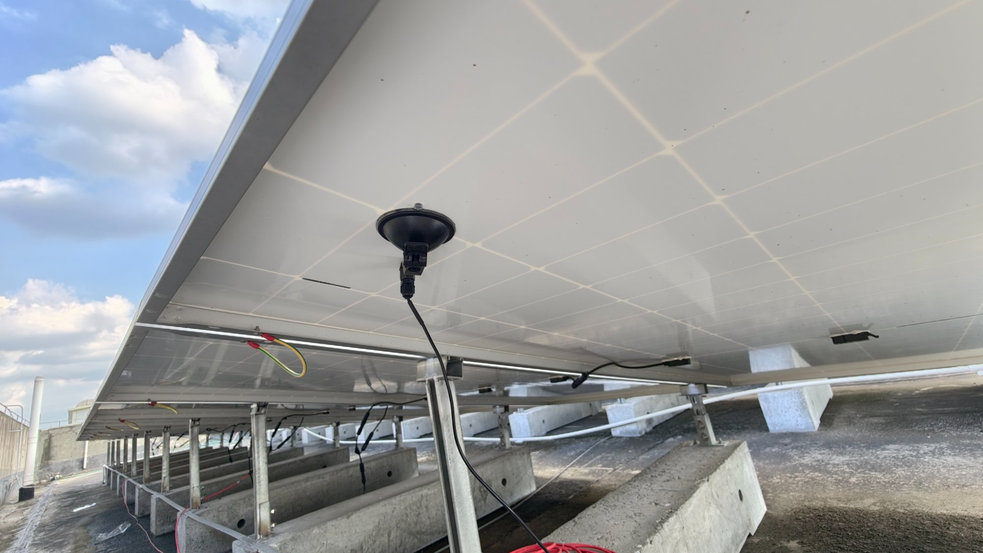 Externer Saugnapf-Temperaturfühler des UNI-T UT381PV montiert an der Unterseite eines Solarmoduls.