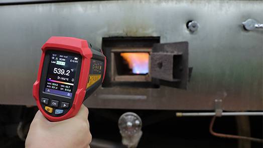 Das UT305C+ Infrarot-Thermometer im industriellen Einsatz bei der Messung der hohen Temperatur eines Ofens, was den extremen Messbereich bis 2200°C demonstriert.